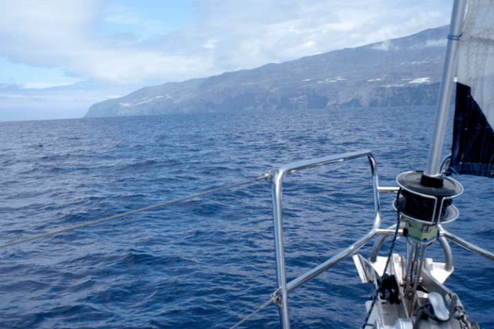 a small boat in a body of water with a mountain in the background