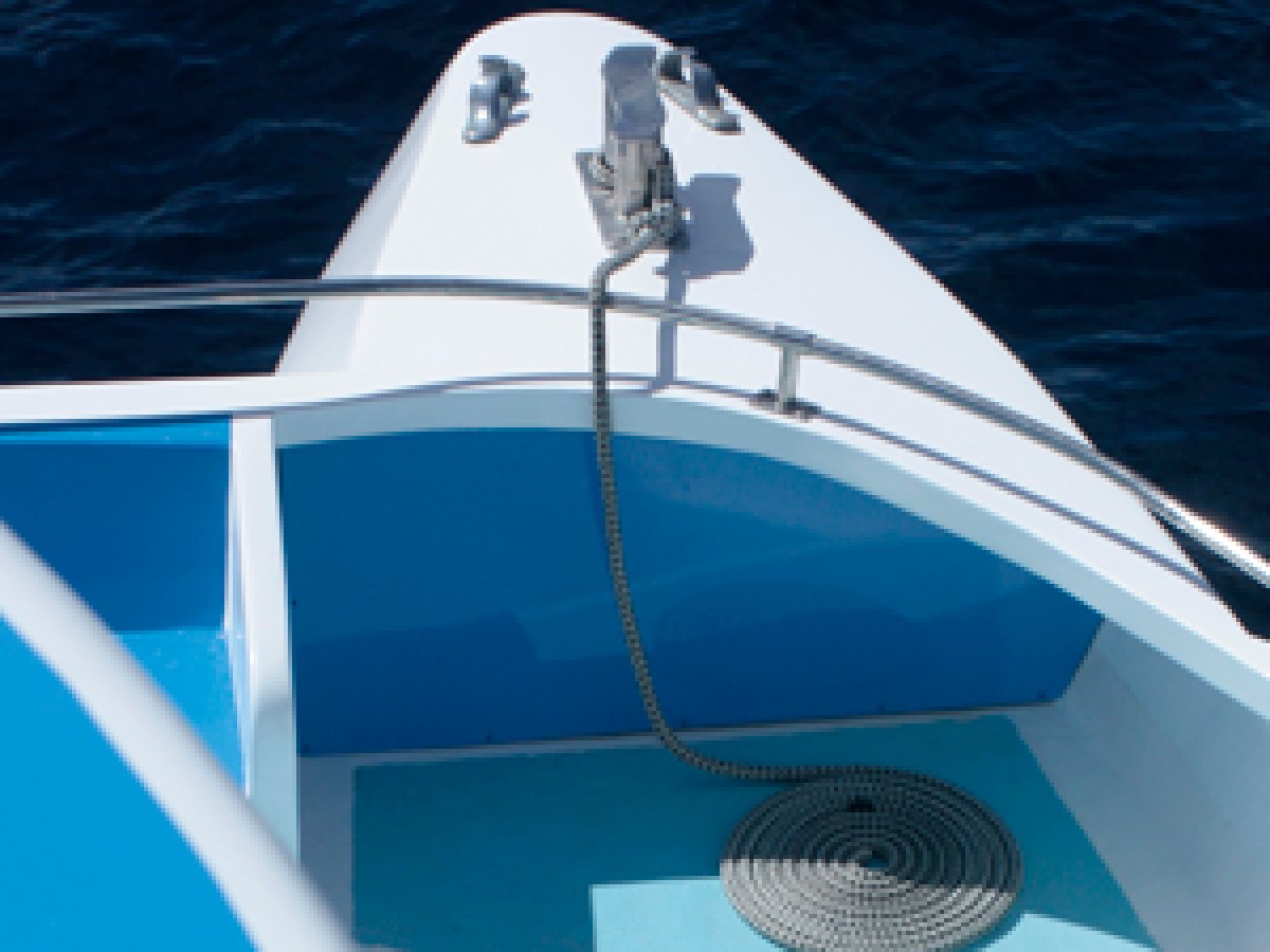 a blue and white boat sitting next to a body of water